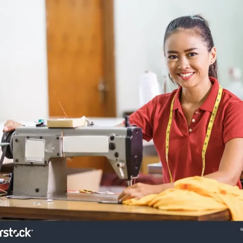 stock-photo-portrait-of-seamstress-in-textile-factory-smiling-while-sewing-with-industrial-sewing-machine-at-1142434055-transformed